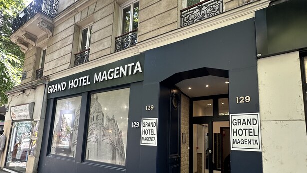 Das Grand Hotel Magenta: eine klassische Fassade mit großen Fenstern und einem Schwarz-Weiß-Farbkonzept.
