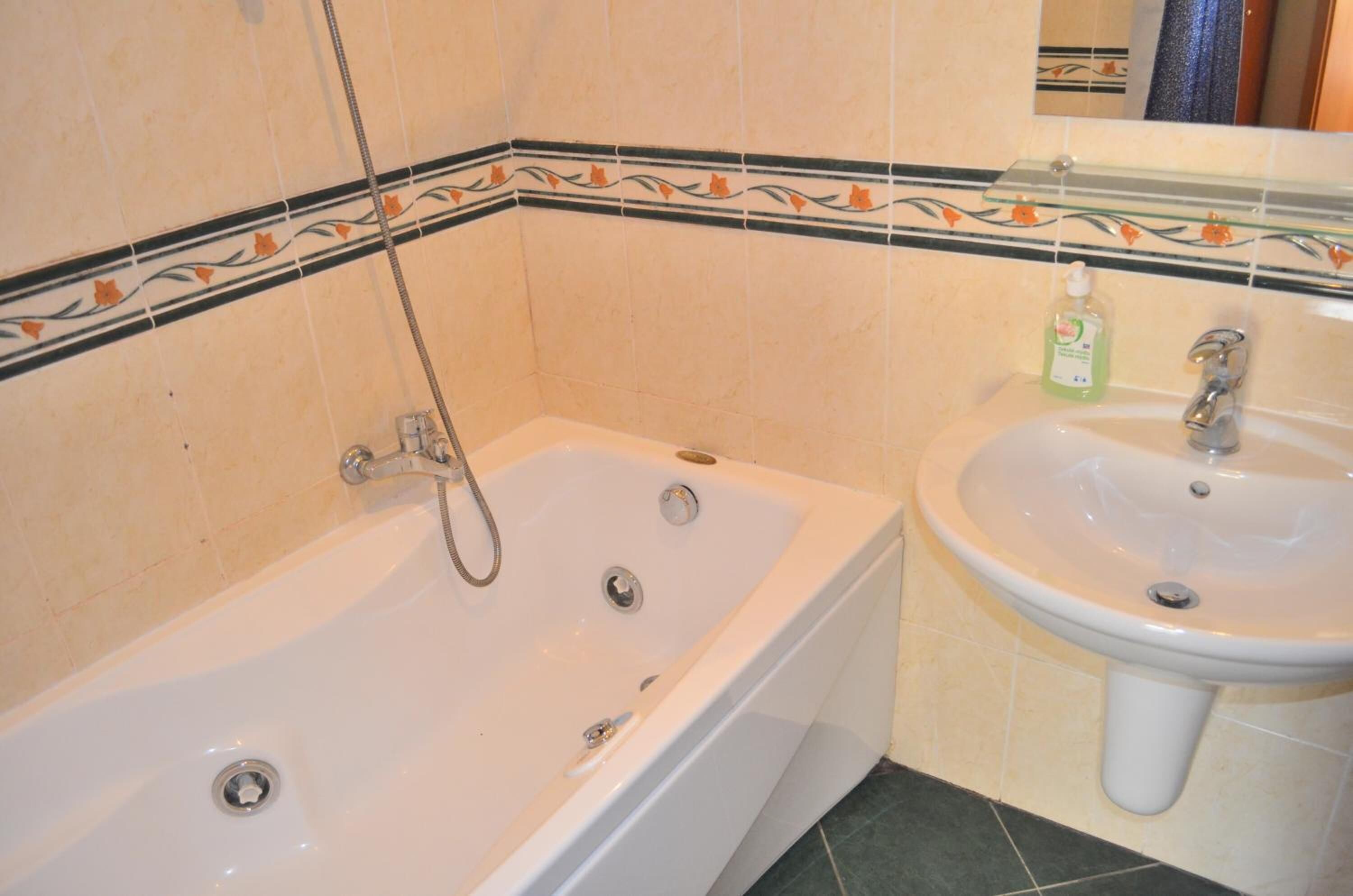 A bathroom with a bathtub, a sink, and a shower.