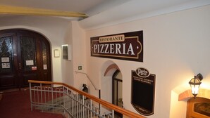 A staircase leading to a pizzeria with a sign above it. - Hotel Petr (Karlovy Vary)