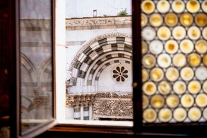 A view through a window with a stone archway and a patterned wall. - L'Antica Bifore (Lucca)