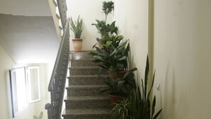 A staircase with granite steps, potted plants, and a metal railing. - Hotel Goartín (Málaga)