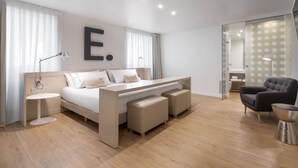 Un dormitorio moderno con una cama grande, mesitas de noche, un escritorio y una silla.