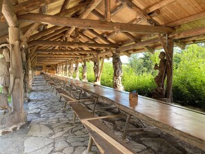 Un espacio al aire libre cubierto con piso de piedra y bancos de madera dispuestos en filas.
