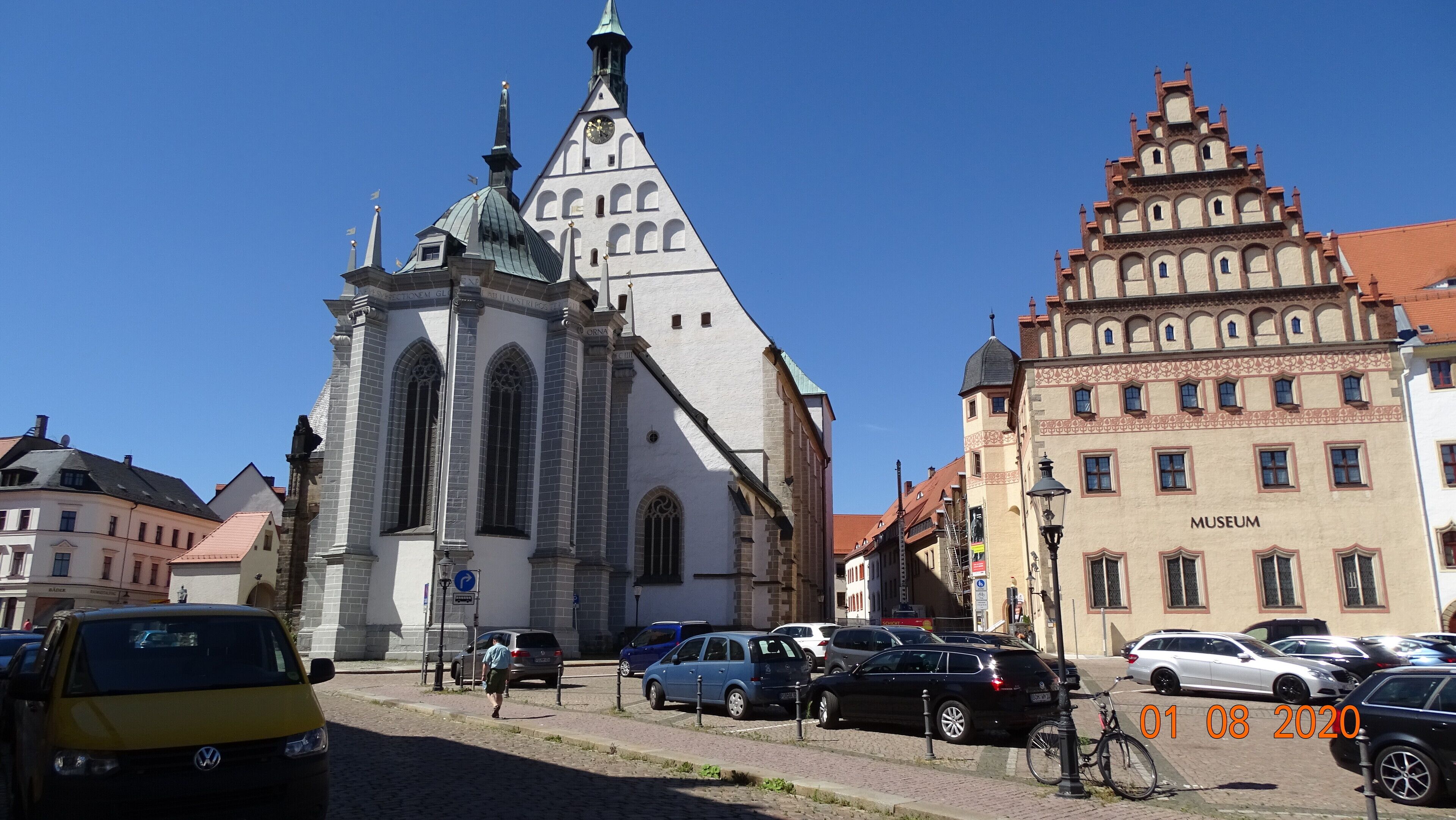 A historic church with a tall steeple and a building labeled "Museum" with a red-tiled roof.