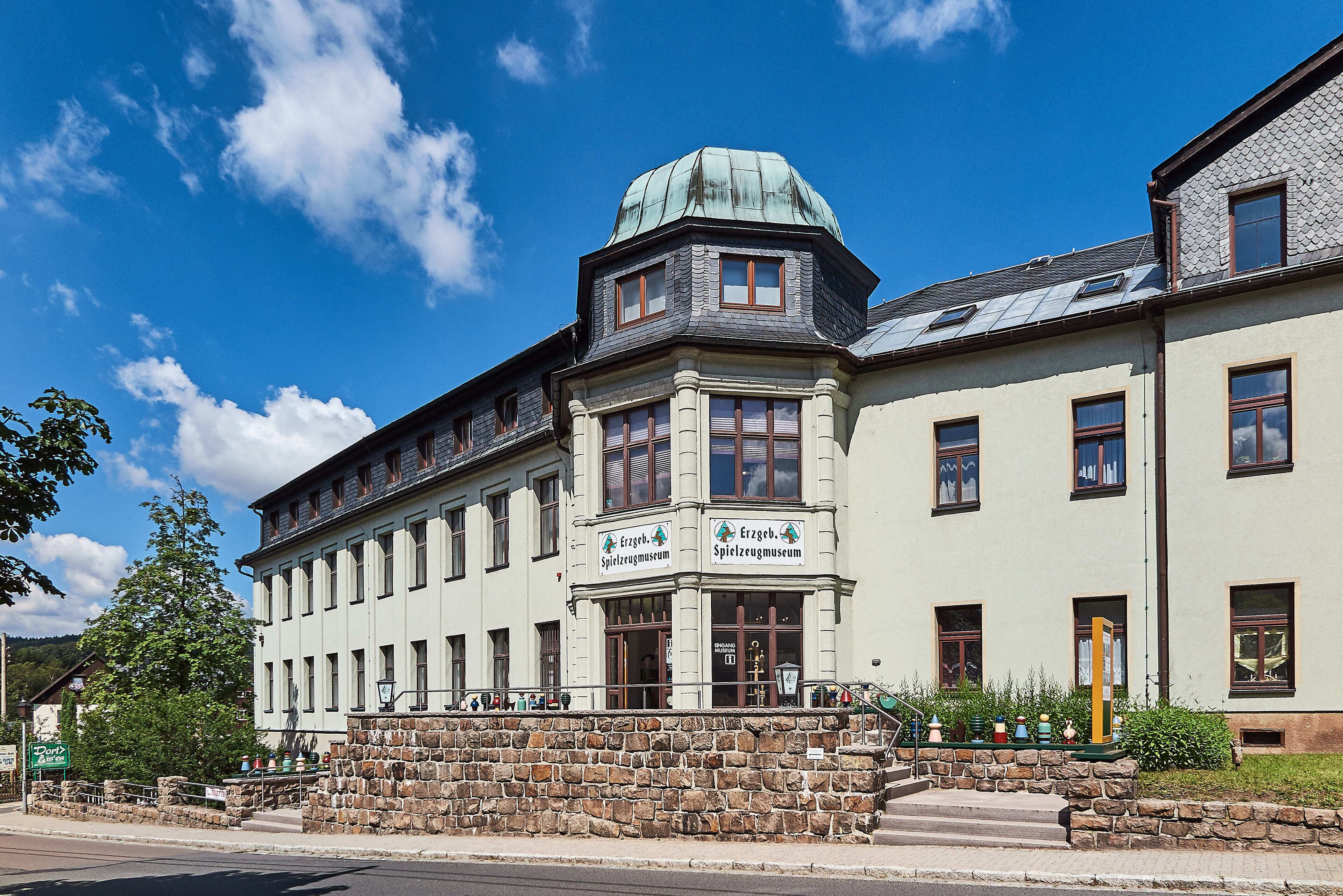 Un edificio histórico con fachada de piedra, varias ventanas y un cartel del Spielzeugmuseum.