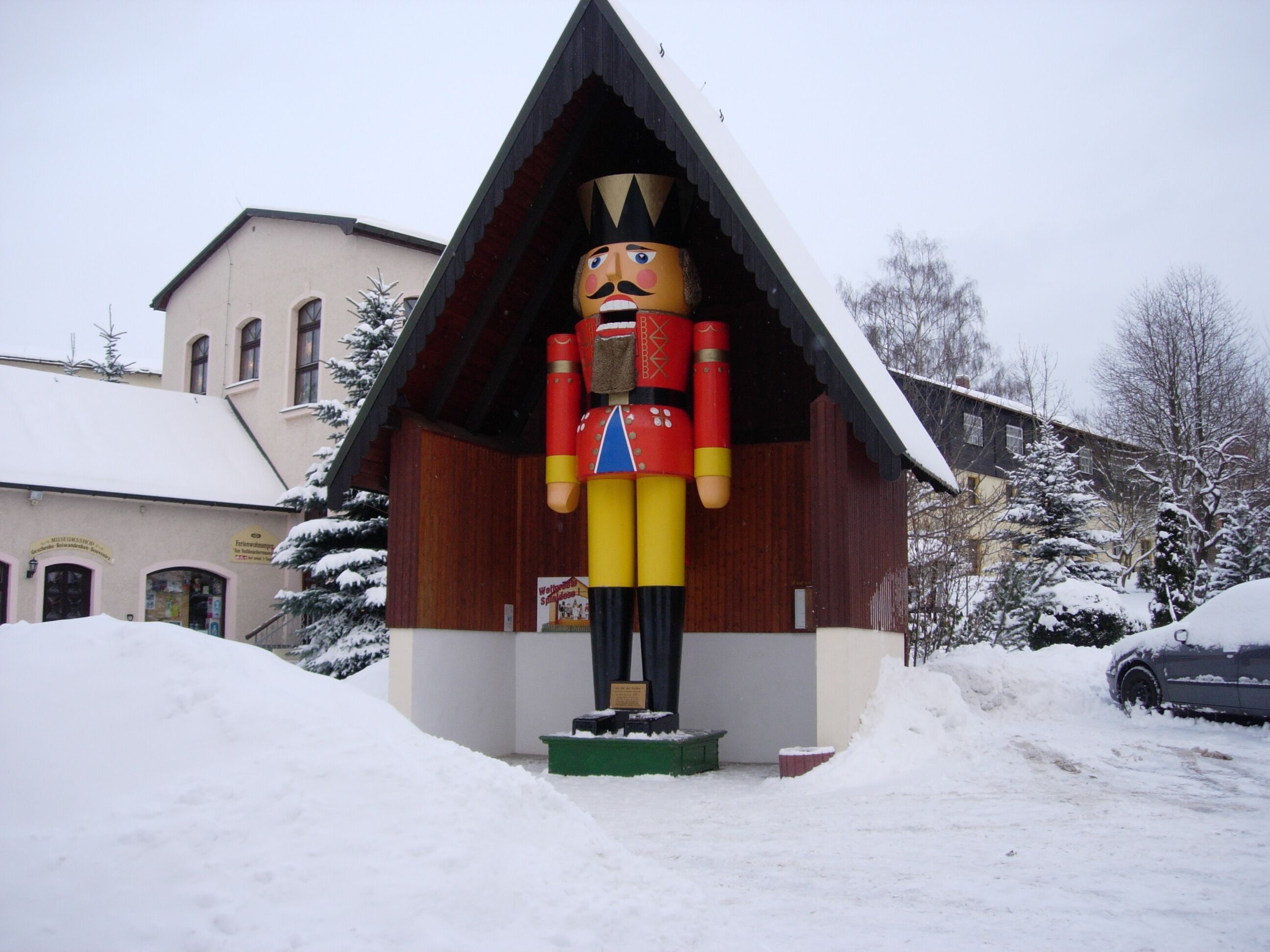 Eine Nussknacker-Statue vor einem Gebäude mit einem geneigten Dach.