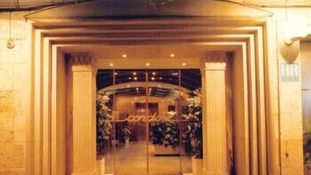 A hotel entrance with a grand archway, a reception desk, and a sign that reads "Hotel". - Cordón (Burgos)