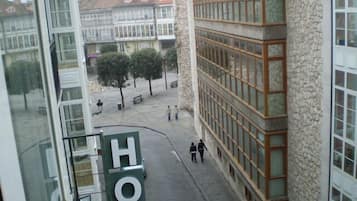 A hotel with a stone facade and large windows. There is a sign with the word "HOTEL" visible.