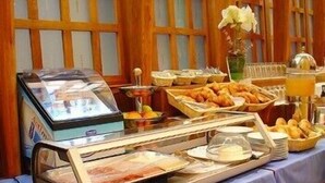 A buffet setup with various food items and a glass display case. - Cordón (Burgos)