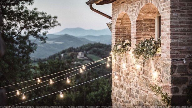 A stone building with arched windows and a string of lights.