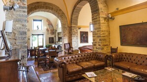 A spacious living room with a leather sofa, a coffee table, and a dining area with a table and chairs.