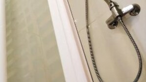A shower with a handheld showerhead and a fixed wall-mounted showerhead.