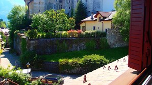 Un edificio al estilo de castillo con fachada de piedra, un foso y un pequeño puente.