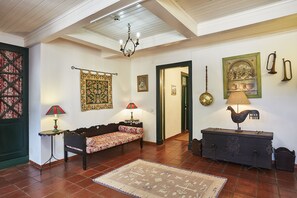 A cozy living room with a wooden bench, a patterned rug, and a decorative lamp. - Casa d'Óbidos (Obidos)
