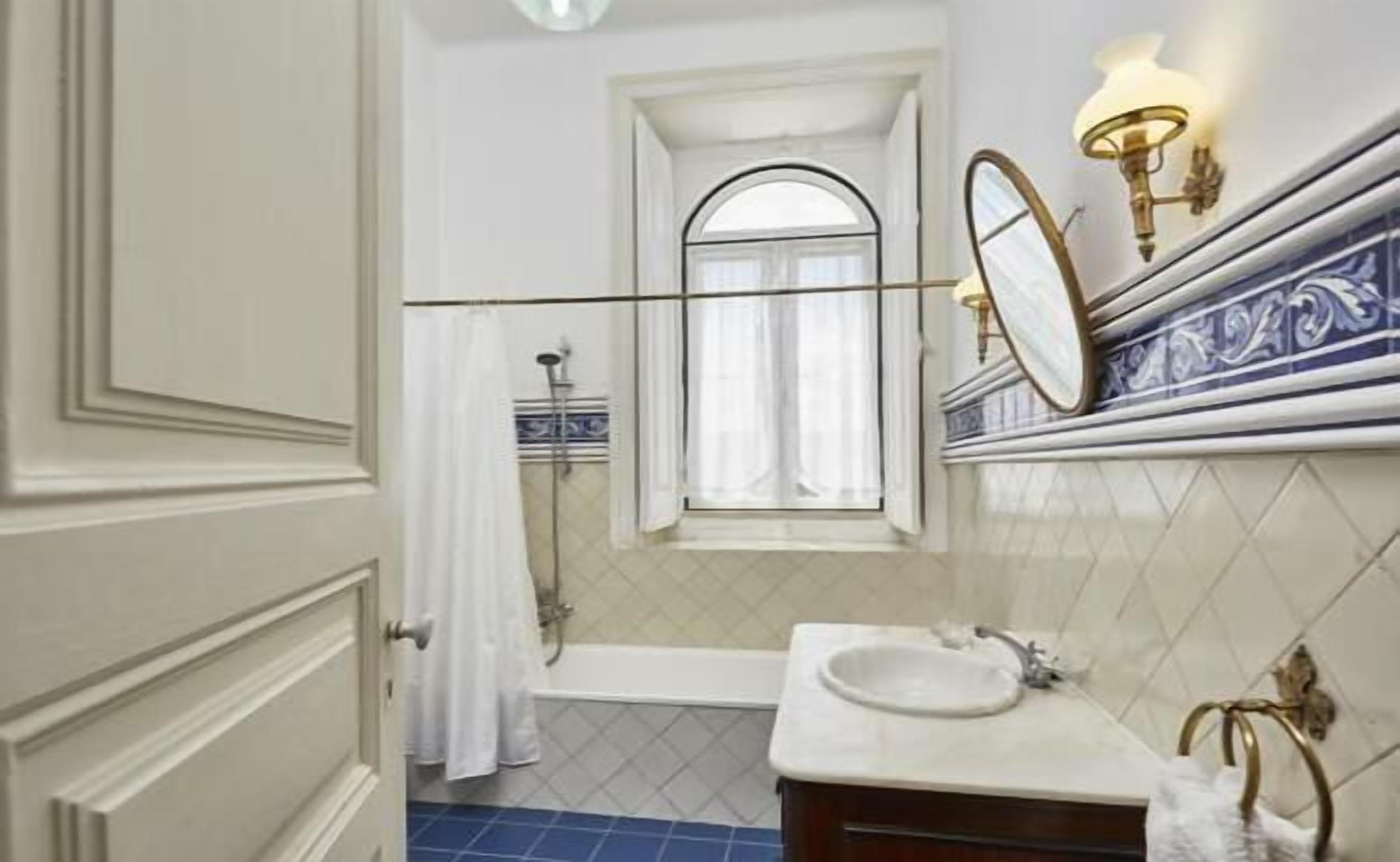 A bathroom with a bathtub, a sink, and a mirror.