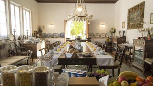 A dining room with a long table set for a meal, surrounded by chairs. - Quinta da Alcaidaria Mór (Ourem)