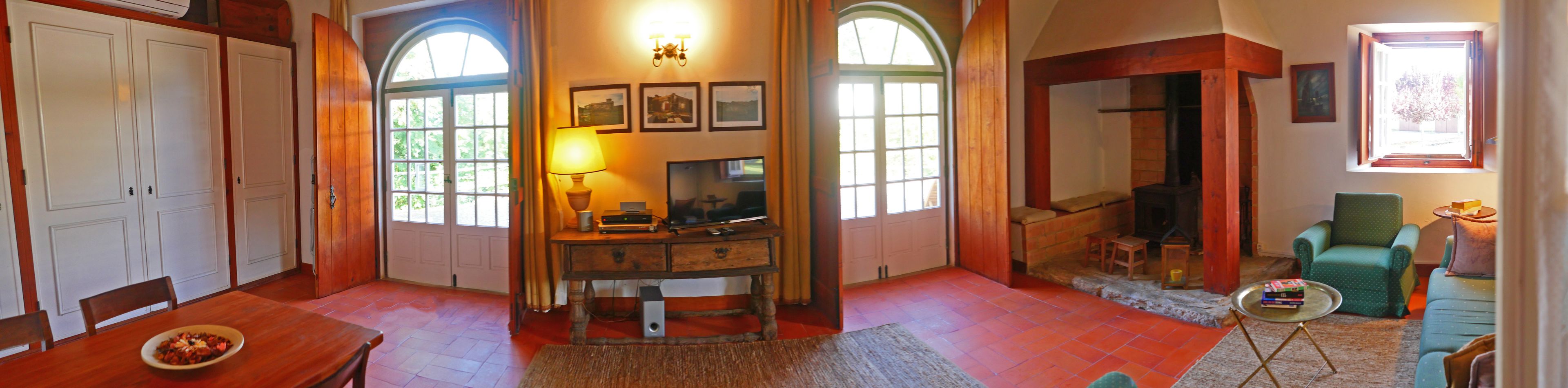 Een gezellige woonkamer met een houten tafel, een televisie en een open haard.