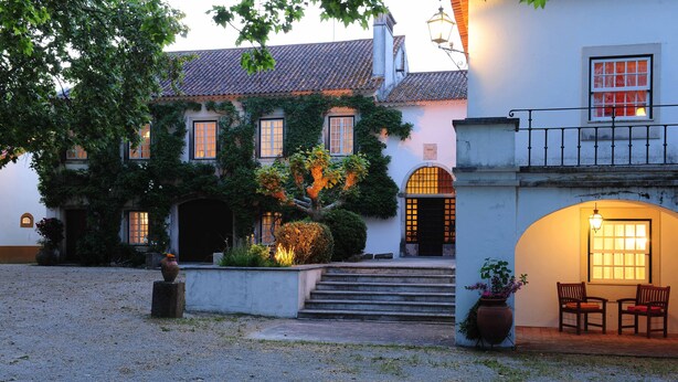 A traditional building with a courtyard, steps leading to the entrance, and a seating area with chairs. - Quinta da Alcaidaria Mór (Ourem)