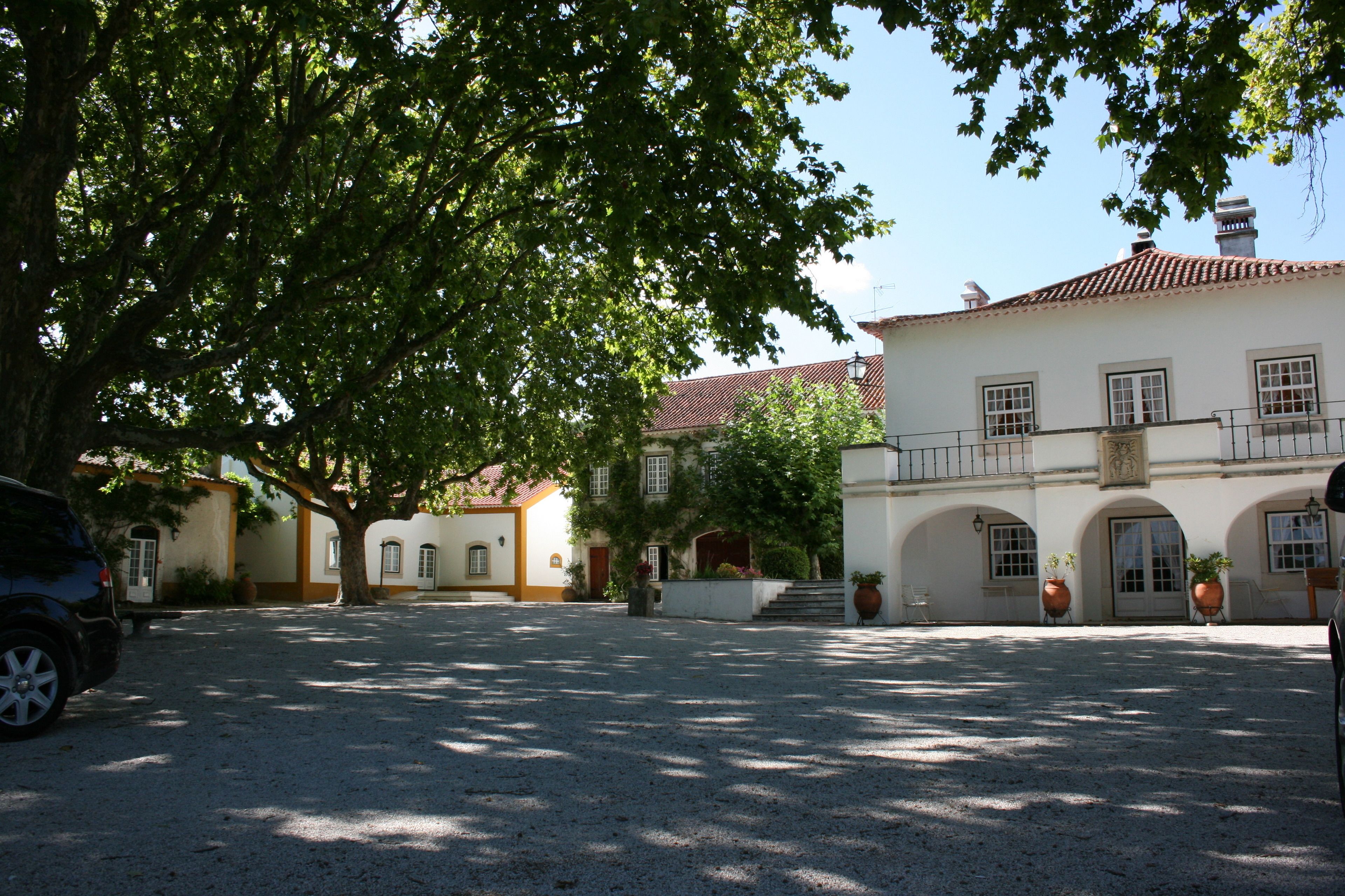A courtyard with a building featuring a tiled roof and arched windows.