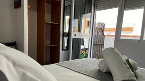 A hotel room with a bed, a wooden wardrobe, and a view of the outside. - Orfebre Góngora (Córdoba)