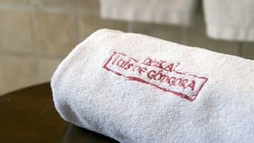 A white towel with embroidered text on a dark surface.