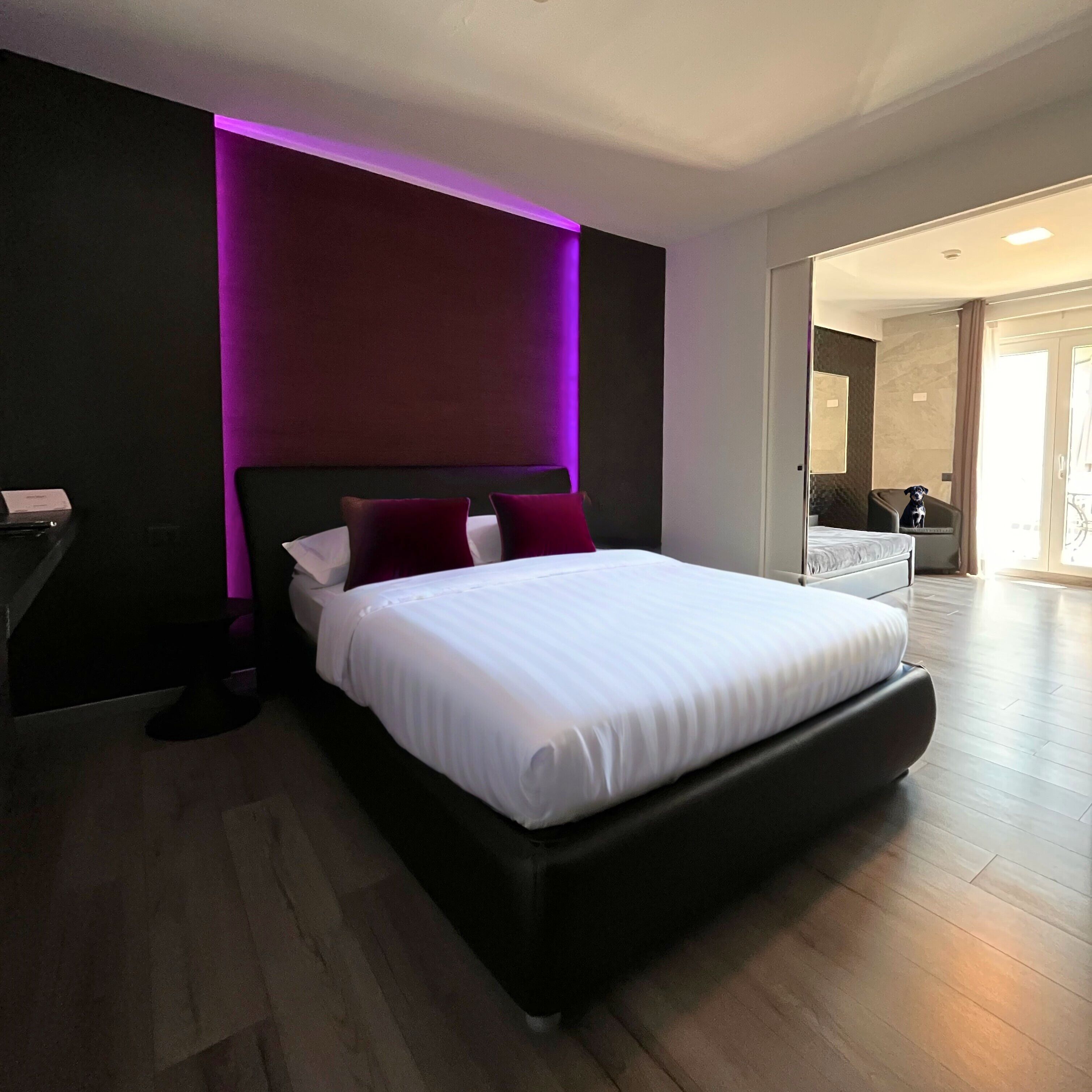A modern hotel room with a large bed, a desk, and a chair.