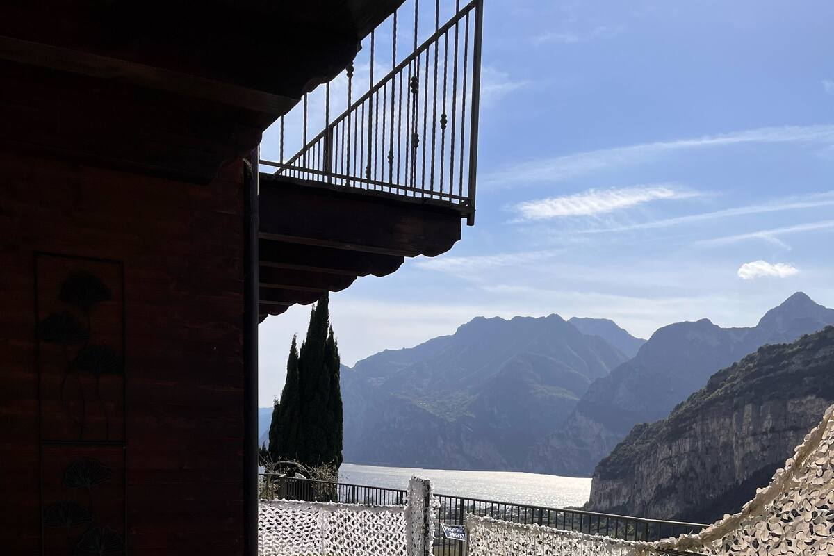 A hot tub with a mountain view, a wooden structure, and a decorative fence.