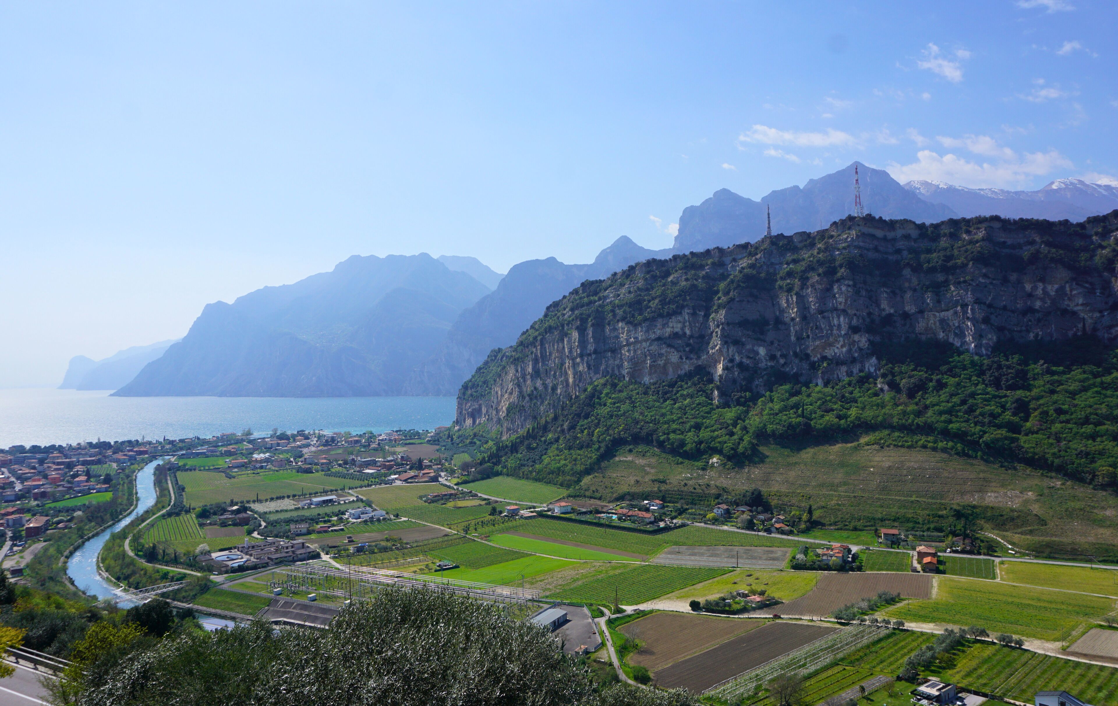 A coastal town with a river, green fields, and mountains in the background.