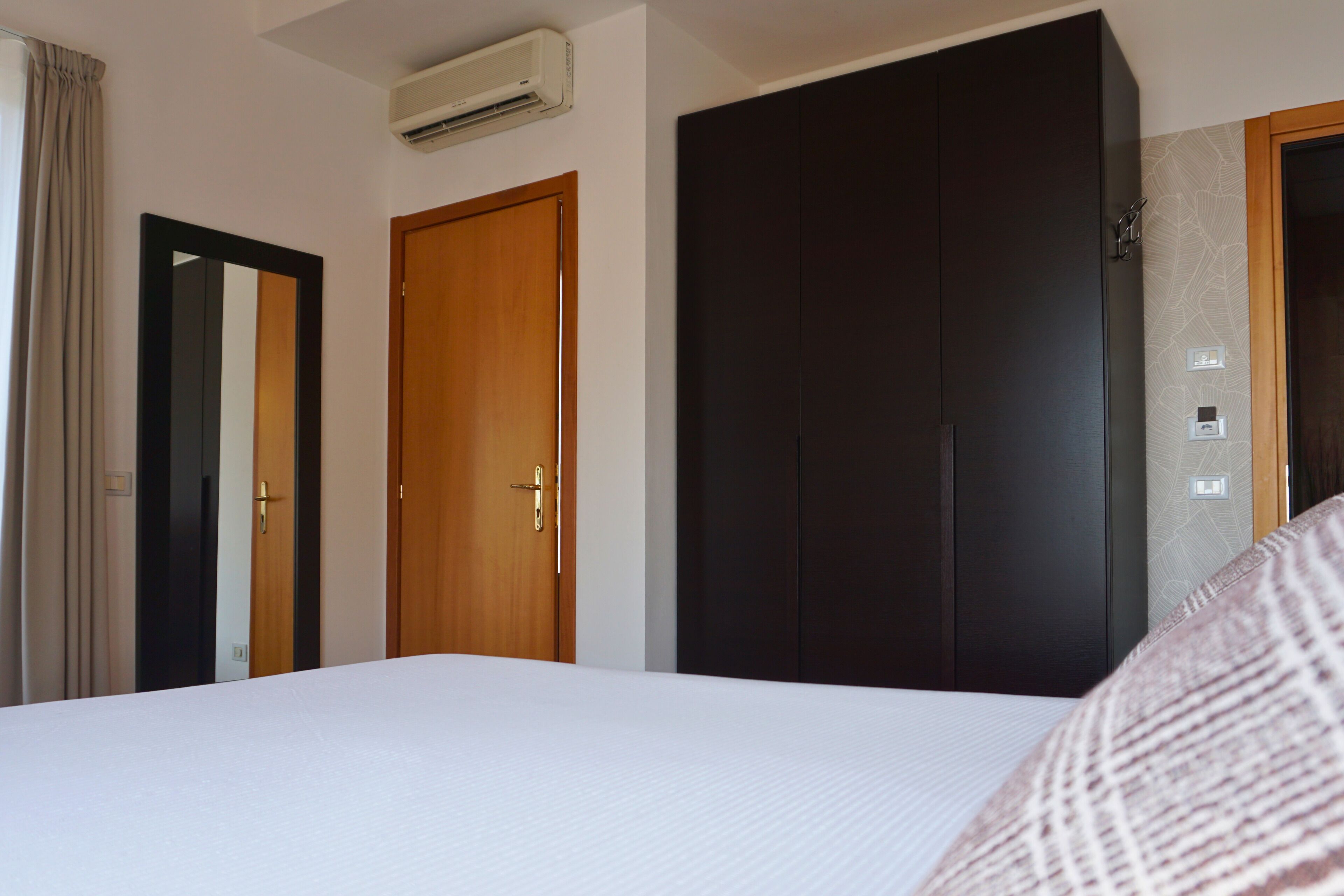 Ein Hotelzimmer mit Bett, Schrank und Tür.