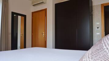 Una habitación de hotel con cama, armario y puerta.