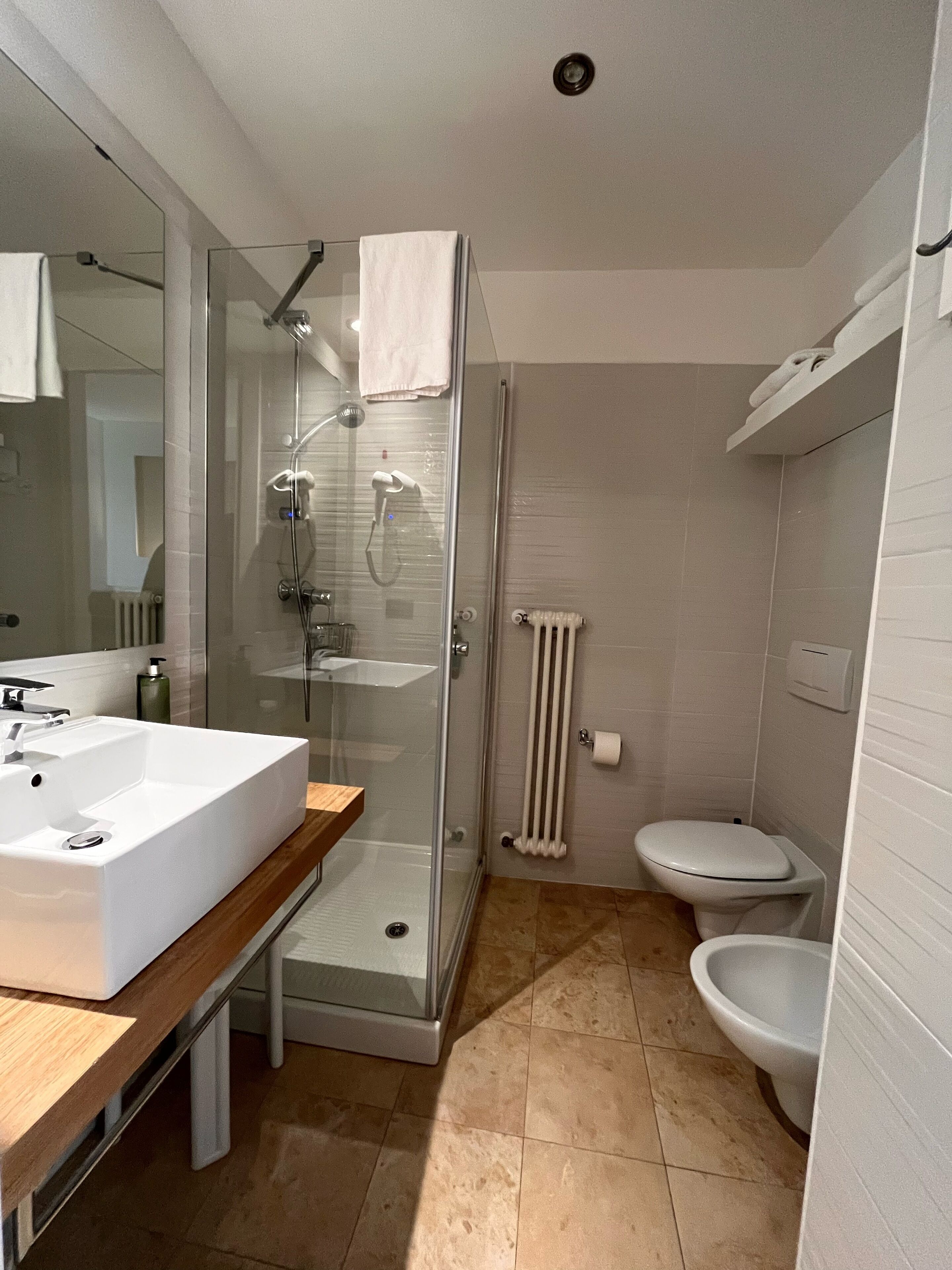 Ein modernes Badezimmer mit einer Duschkabine, einem weißen Waschbecken und einer Toilette.