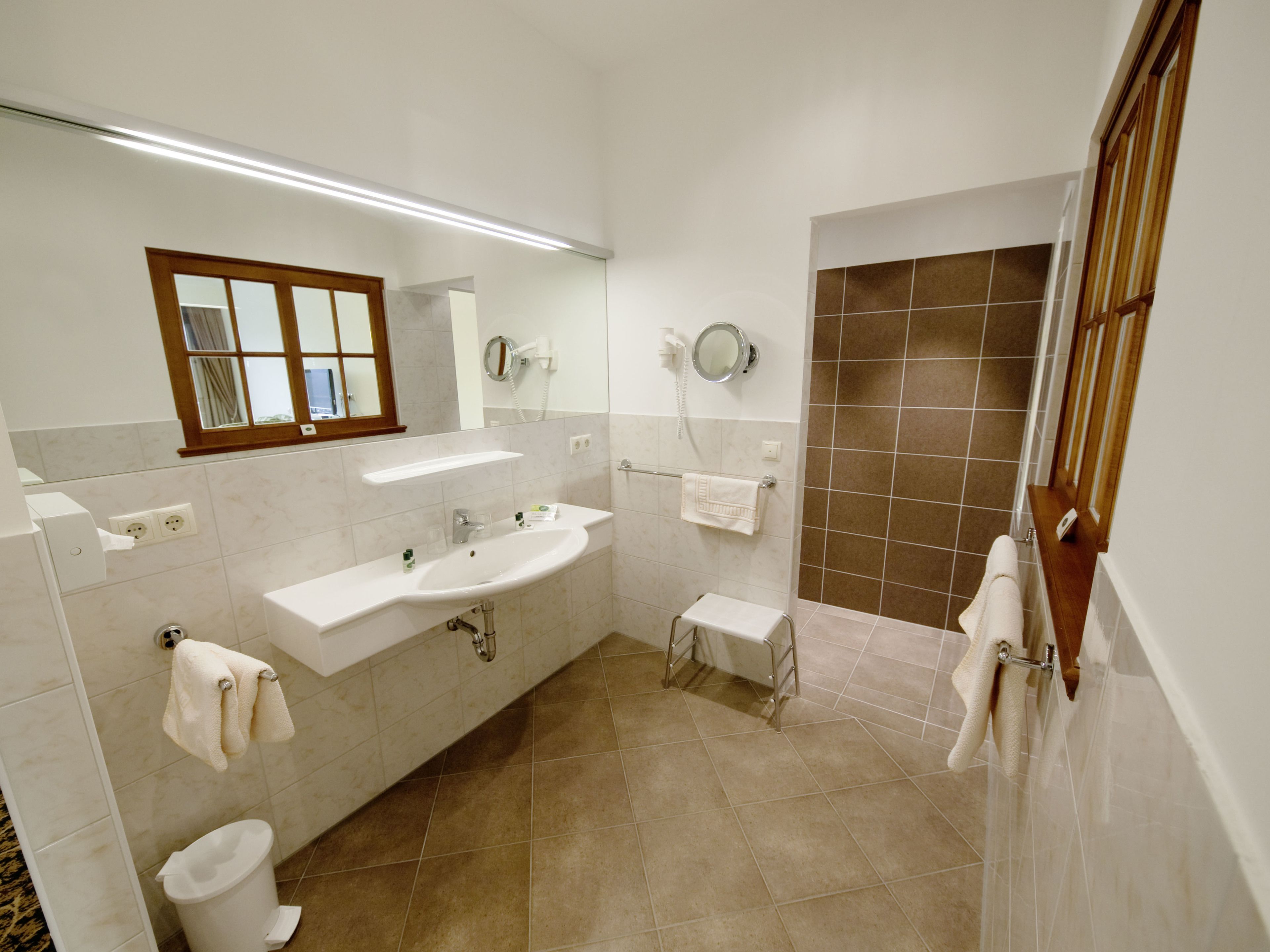 A modern bathroom with a sink, mirror, and toilet.