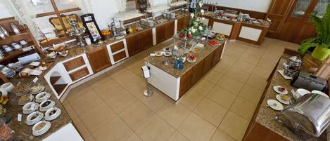 Una cocina amplia con una isla central, equipada con diversos electrodomésticos y un sistema tipo bufé.