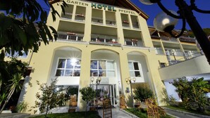 A hotel with a yellow facade, multiple balconies, and a clear sky. - Gartenhotel & Weingut Pfeffel Dürnstein (Durnstein)