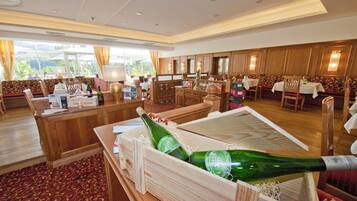A hotel lobby with wooden furniture, a reception desk, and a large wooden crate filled with bottles.