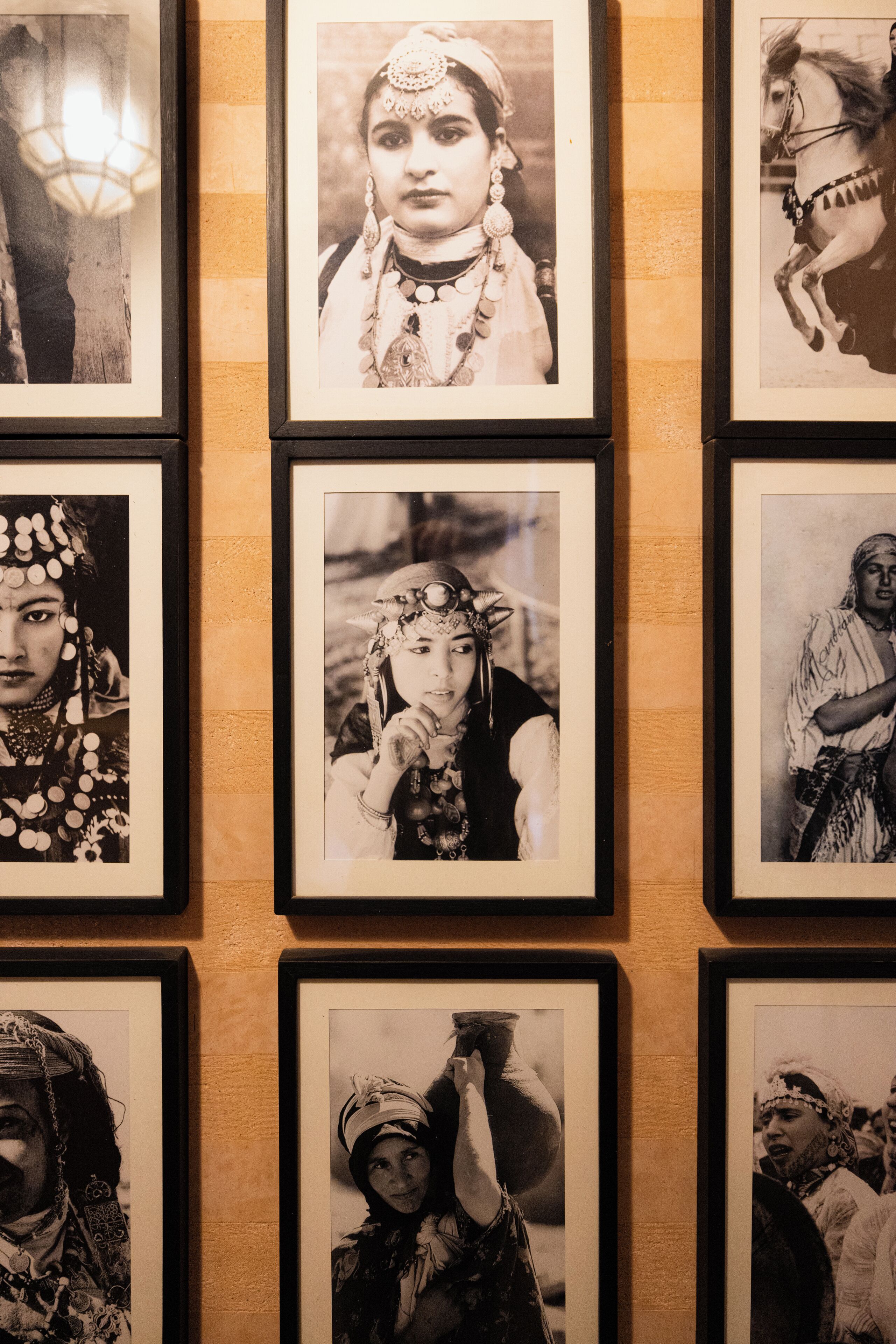A wall with multiple framed black and white photographs.