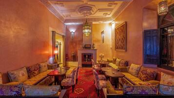 A traditional interior with sofas, tables, and a fireplace.