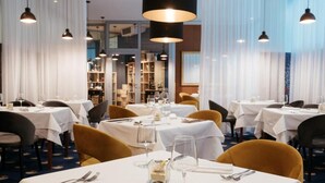 A restaurant with multiple tables set for dining, featuring white tablecloths and a variety of chairs. - Depandance Vila Higiea - Terme Dobrna (Dobrna)