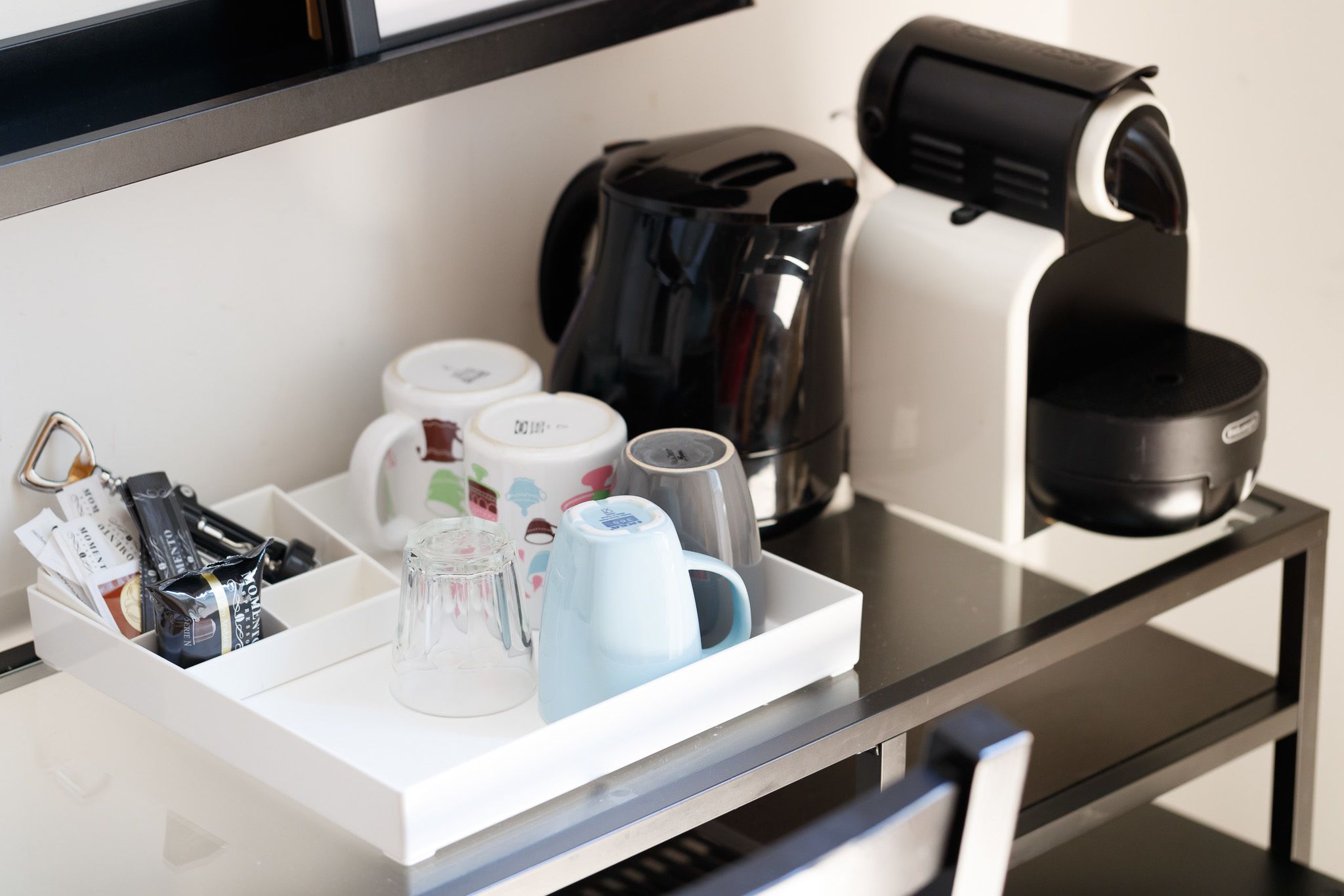 Una encimera de cocina con cafetera, hervidor y máquina de café.