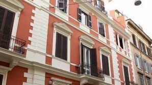 A multi-story building with a red facade, white trim, and balconies. - Maximus (Rome)
