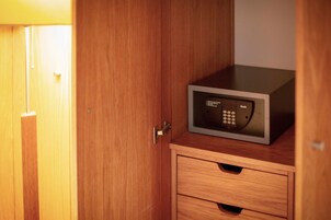 Un mobiletto in legno con un forno a microonde sopra e un cassetto sotto.
