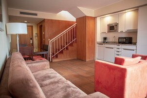 Ein modernes Wohnzimmer mit einer Treppe, die in einen Küchenbereich führt.