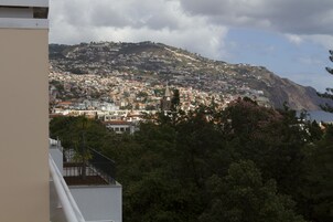Un pueblo costero con una colina destacada, edificios residenciales densos y vistas al mar.
