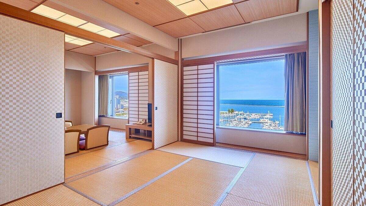 Ein traditioneller japanischer Raum mit Tatami-Böden, Schiebetüren und Meerblick.