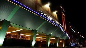 Vista nocturna del Hotel Grand Park, con su señalización iluminada y arquitectura moderna.