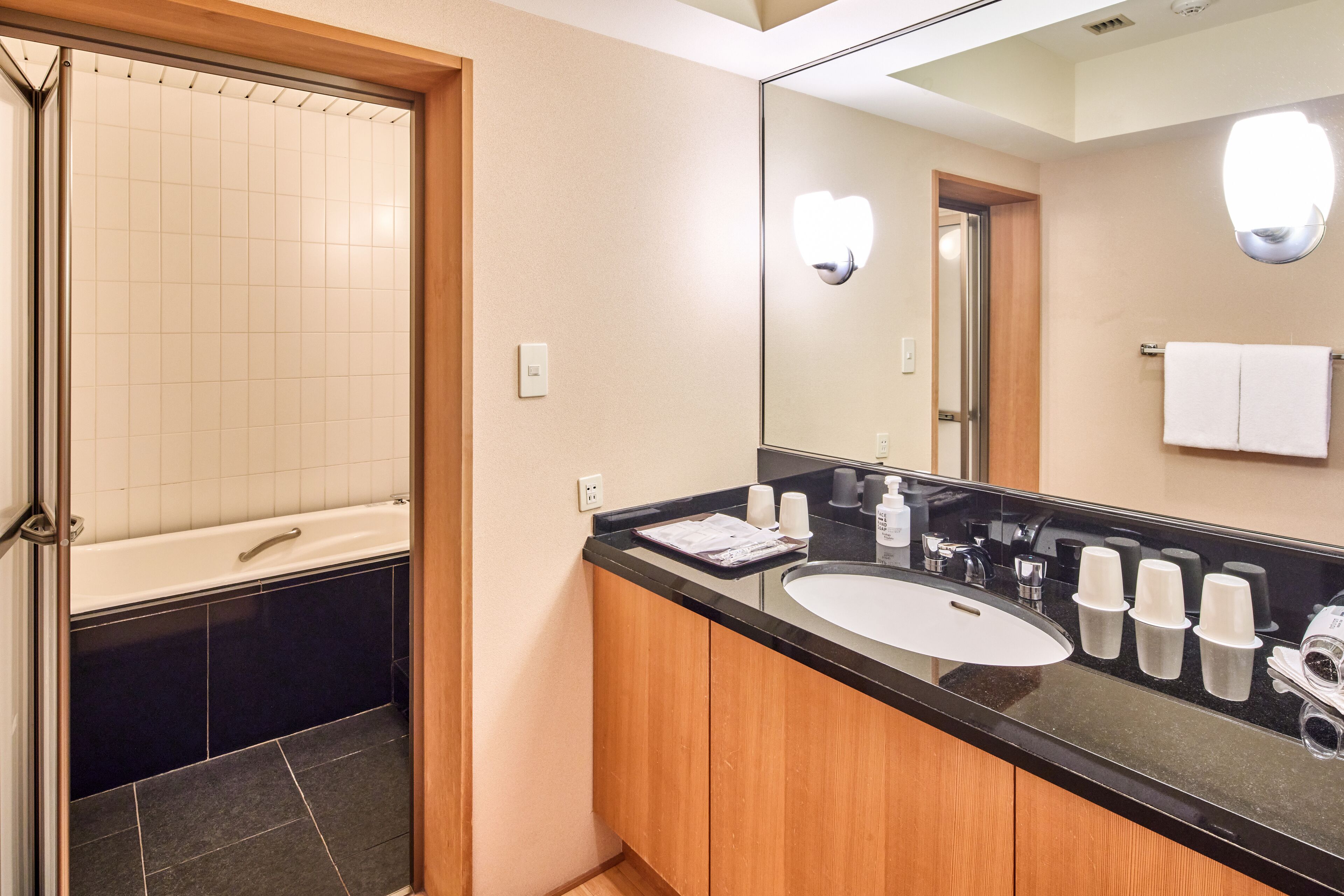 A bathroom with a bathtub, a sink, and a mirror.