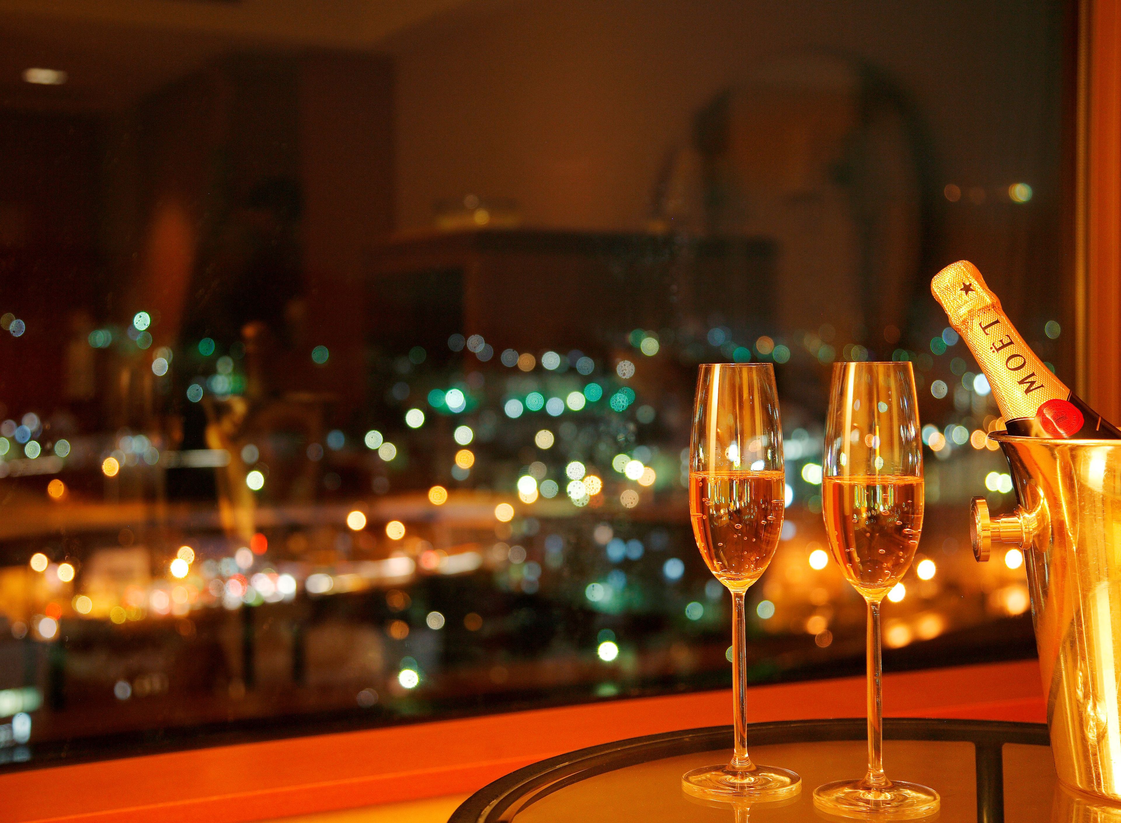 Two champagne glasses on a table with a bottle of Moët champagne.