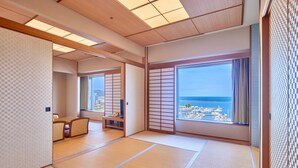 Una habitación japonesa tradicional con suelo de tatami, puertas correderas y vista al mar.