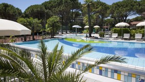 Una piscina al aire libre, sombrillas, tumbonas