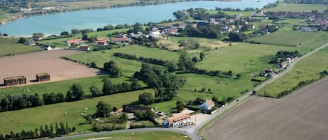 Un paisaje rural con un pequeño pueblo, campos y un lago.